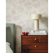 Chambre lumineuse avec papier peint intissé à fleurs, table de chevet en bois, lampe à poser beige et tête de lit verte.