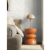 Chambre moderne avec mur texturé, table de chevet sculpturale orange, lampe champignon et lit avec tête de lit en tissu bouclé.