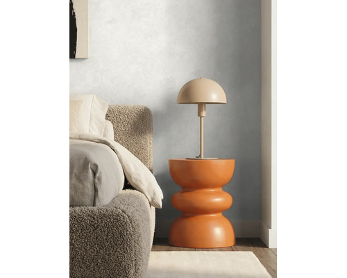 Chambre moderne avec mur texturé, table de chevet sculpturale orange, lampe champignon et lit avec tête de lit en tissu bouclé.