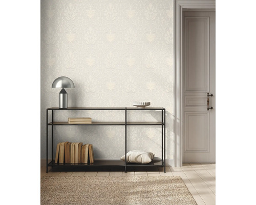 Pièce lumineuse avec un papier peint baroque à motifs, une console en métal et une porte