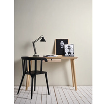 Espace de travail minimaliste avec bureau en bois clair avec tiroir, chaise noire moderne et lampe de bureau noire.