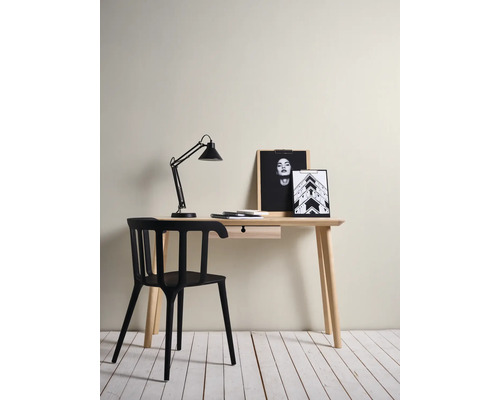 Espace de travail minimaliste avec bureau en bois clair avec tiroir, chaise noire moderne et lampe de bureau noire.