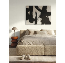 Chambre à coucher moderne et lumineuse avec un lit en tissu bouclé, une peinture murale abstraite, une table d'appoint sculpturale et une lampe.