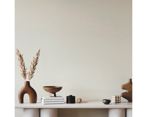 Papier peint texturé clair dans une pièce moderne avec console blanche et décoration aux tons terreux.