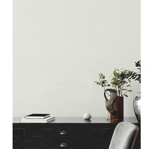 Papier peint structuré dans une scène d'intérieur moderne avec un bureau sombre, des livres, une sculpture de main et une plante.