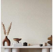 Papier peint intissé avec structure horizontale derrière une console minimaliste décorée de vases et de fleurs séchées.