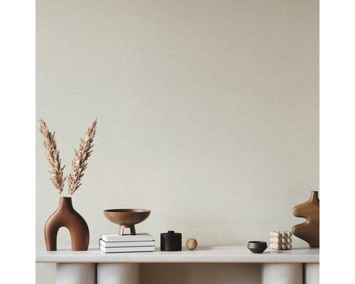 Papier peint intissé avec structure horizontale derrière une console minimaliste décorée de vases et de fleurs séchées.