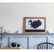 Poster encadré avec carte de l'Islande sur une étagère dans une pièce lumineuse au design moderne avec des panneaux muraux et de la décoration.