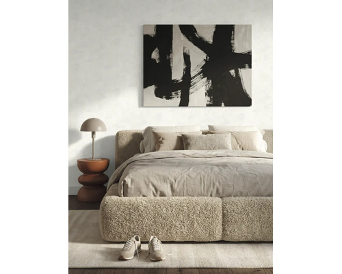 Chambre moderne avec cadre de lit en bouclé, linge de lit aux tons naturels, tableau abstrait et lampe de table en forme de champignon.