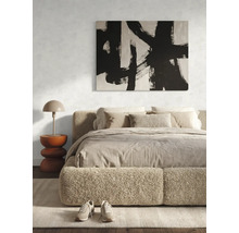 Chambre à coucher moderne avec lit capitonné, tableau abstrait en noir et blanc et table de chevet avec lampe.