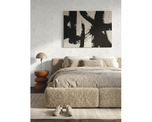 Chambre à coucher moderne avec lit capitonné, tableau abstrait en noir et blanc et table de chevet avec lampe.