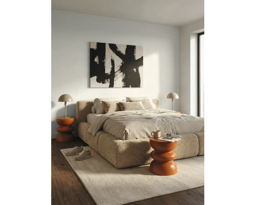 Chambre à coucher moderne avec lit rembourré en tissu bouclé, deux tables de chevet avec lampes et un tableau abstrait.