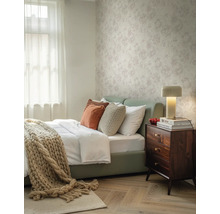Papier peint intissé à motif floral dans une chambre lumineuse avec table de chevet en bois et parquet.
