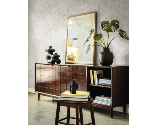Buffet en bois foncé avec motif à carreaux, décoré de vases et d une plante devant un mur avec papier peint floral dans un salon lumineux.