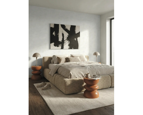 Chambre moderne avec lit en bouclé, tableau abstrait et tables d appoint sculpturales sur un tapis clair et parquet.