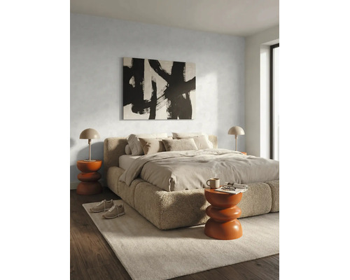 Chambre moderne avec lit capitonné en tissu bouclé, linge de lit neutre, tables de chevet orange et décoration murale abstraite.