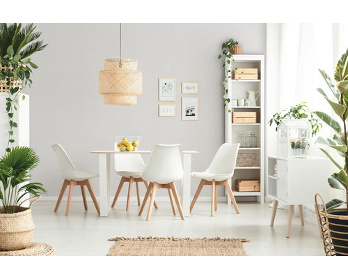 Salle à manger moderne et lumineuse avec table blanche, chaises aux pieds en bois, grande suspension en osier, étagère blanche et plantes vertes.