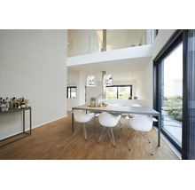 Salle à manger moderne et lumineuse avec table grise, chaises coques blanches, suspensions argentées et parquet en bois.