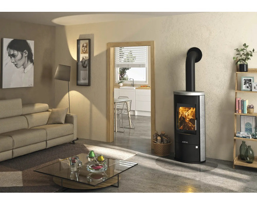 Modernes helles Wohnzimmer mit Justus Kaminofen aus Metall und Stein mit brennendem Feuer, Sofa und Glastisch.