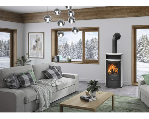 Moderner Wohnraum mit freistehendem Kaminofen aus schwarzem Stahl mit weißer Verkleidung, grauem Sofa, Holztisch und großen Fenstern.