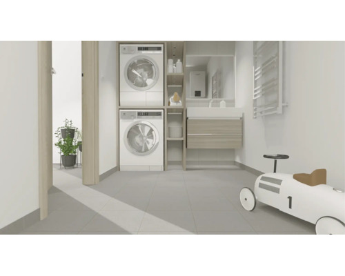 Buanderie moderne avec lave-linge et sèche-linge superposés, meuble sous-vasque aspect bois et carrelage au sol.