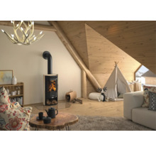 Moderner Kaminofen mit Steinverkleidung in einem hellen Wohnraum mit Holzdecke, Geweihleuchter und Spielzelt.
