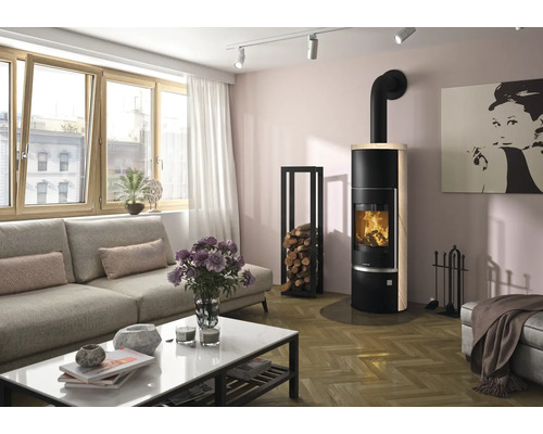 Poêle à bois moderne dans un salon lumineux avec parquet, canapé, table basse et étagère à bois de chauffage.