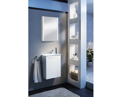 Salle de bains moderne et lumineuse avec meuble sous-lavabo blanc, lavabo et armoire de toilette avec éclairage LED vertical sur un mur gris.
