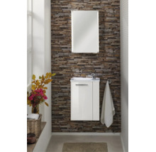 Meuble de salle de bains moderne avec meuble sous-lavabo blanc et miroir avec éclairage intégré sur un mur décoratif en aspect pierre.