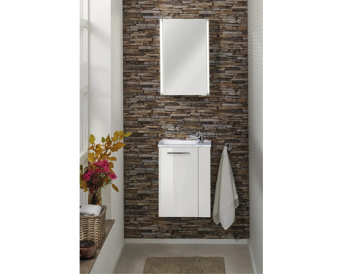 Meuble de salle de bains moderne avec meuble sous-lavabo blanc et miroir avec éclairage intégré sur un mur décoratif en aspect pierre.