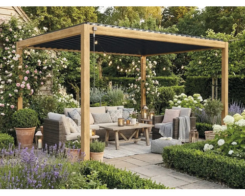 Holzpergola mit schwarzem Lamellendach auf einer Terrasse. Mit Rattan-Loungemöbeln, Holztisch und Gartenpflanzen wie Lavendel und Rosen.