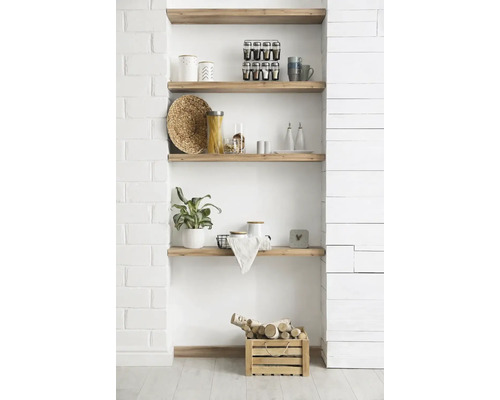 Niche murale avec quatre étagères en bois massif, décorée d'ustensiles de cuisine, d'une plante et d'une caisse en bois avec du bois de chauffage.