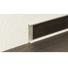 Profilé de plinthe en métal argenté avec insert aspect bois foncé à la jonction du mur et du sol.