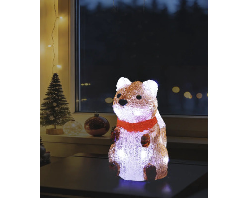 Figurine lumineuse en acrylique representant un ecureuil avec echarpe rouge sur une table, decoration de Noel avec sapin en fond.