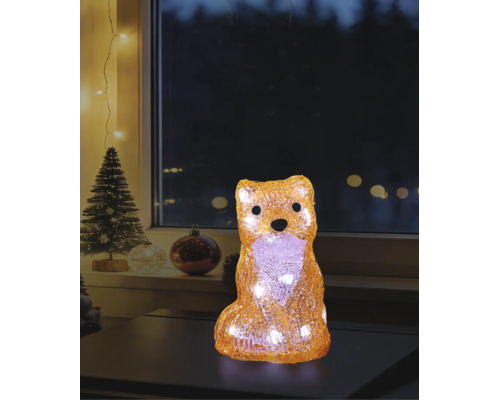 Figurine de renard décorative à LED en acrylique avec lumière blanc chaud dans une ambiance de Noël sur une table devant une fenêtre.