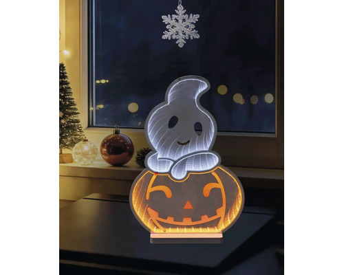 Décoration d'Halloween LED avec un fantôme sur une citrouille et effet de miroir infini, posée sur une table devant une fenêtre avec des décorations.