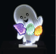 Décoration lumineuse pour Halloween fantôme souriant avec effet miroir infini et inscription Boo lumineuse sur un socle blanc.
