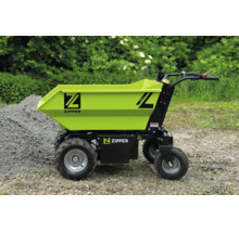Dumper électrique Zipper avec grande benne et quatre roues sur du gravier à côté d'un tas de pierres.