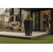 Hoher, quadratischer Pflanzkübel auf einer modernen Terrasse mit Gartenmöbeln und Teppich.
