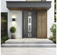 Porte d entrée moderne avec quatre inserts en verre rectangulaires et une longue poignée barre sur des marches en béton à côté d une façade en bois.