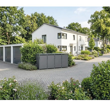 Cache-poubelle moderne en métal pour quatre poubelles dans une entrée de garage devant une maison blanche.