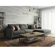 Salon moderne et lumineux avec panneaux muraux aspect bois, canapé d'angle gris foncé, table basse en bois et tapis à motifs.