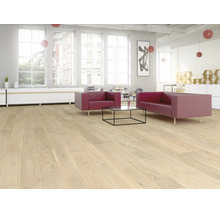 Espace de vie lumineux avec parquet en bois clair, canapés rouges, table basse en verre et grandes fenêtres dans un style loft.