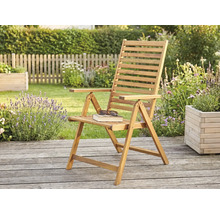 Fauteuil de jardin pliant en bois sur une terrasse en bois dans un jardin lumineux avec des plantes et une clôture.