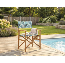 Chaise de metteur en scène en bois avec motif de feuilles de palmier sur une terrasse en bois à côté d'une piscine dans un jardin.
