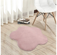Blütenförmiger, weicher Teppich in Rosa auf hellem Holzboden neben einem Stuhl.