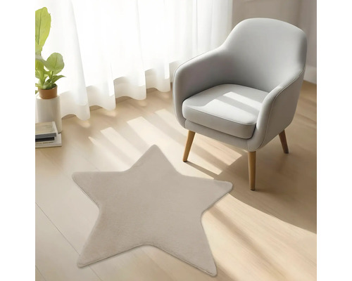 Tapis en peluche en forme d'étoile sur un sol en bois clair dans une pièce lumineuse à côté d'un fauteuil gris moderne.