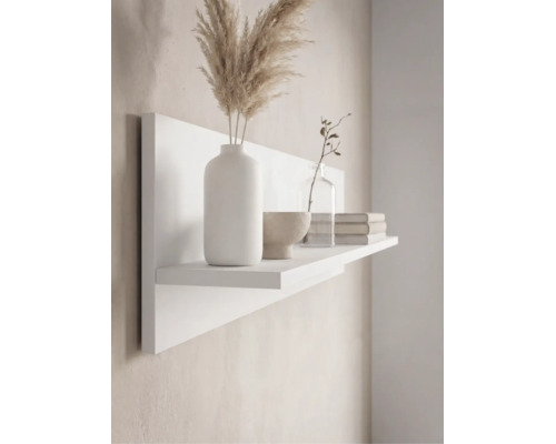 Étagère murale blanche avec panneau arrière, décorée d'un vase, de l'herbe de la pampa, d'un bol, d'une bouteille en verre et de livres.