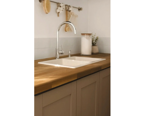 Cuisine moderne et lumineuse avec un évier double encastré dans un plan de travail en bois, un mitigeur et des meubles bas.