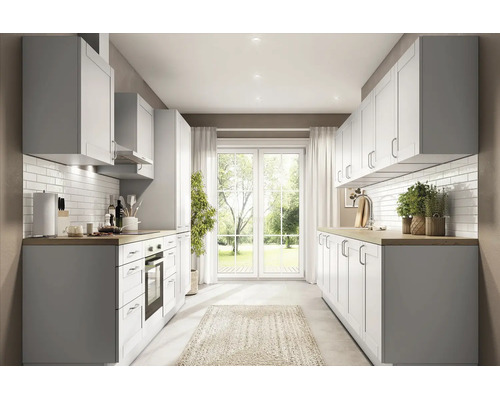 Cuisine intégrée moderne et lumineuse avec plan de travail en bois, façades de style campagnard, crédence blanche et vue sur le jardin.